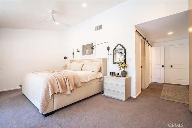 bedroom with a barn door, visible vents, carpet flooring, and recessed lighting