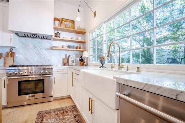 5910 Pat Ave, Woodland Hills, CA 91367 - kitchen with light stone counters, stainless steel appliances, light wood-style flooring, and extractor fan