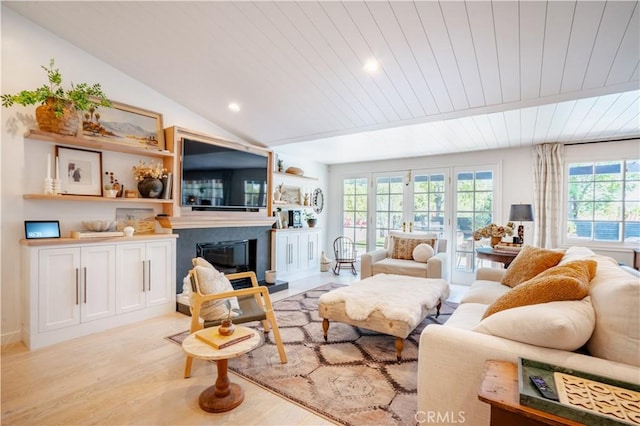 living room featuring lofted ceiling, wooden ceiling, light wood-style flooring, and a glass covered fireplace