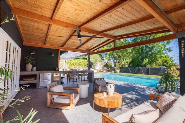 view of patio / terrace featuring a fenced in pool, an outdoor kitchen, an outdoor hangout area, ceiling fan, and a fenced backyard