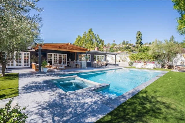 view of pool with a patio area, a pool with connected hot tub, fence, and french doors