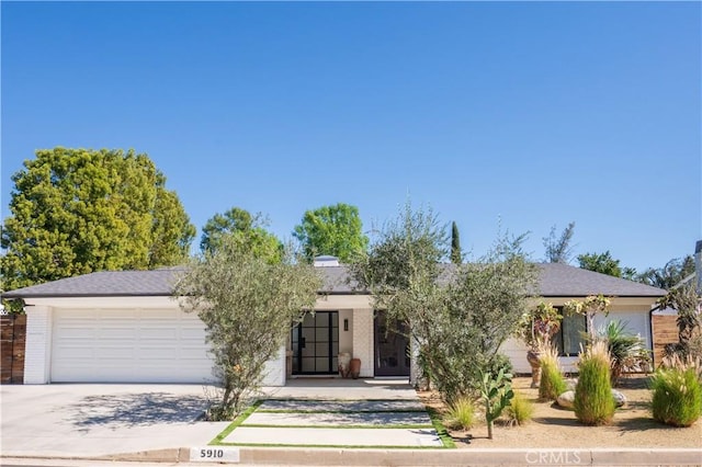 view of front of property featuring concrete driveway and an attached garage