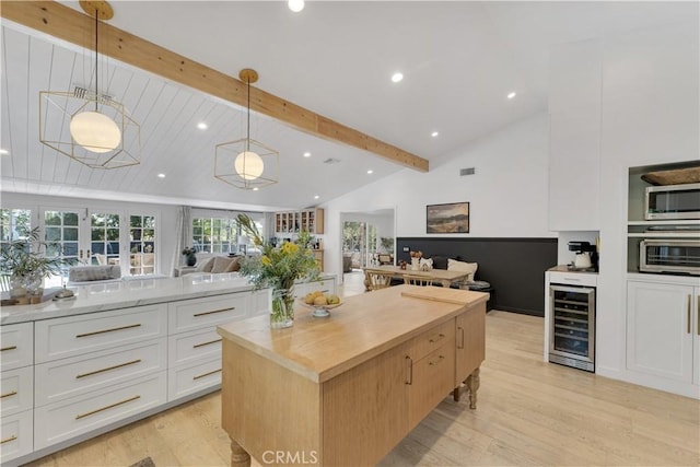 5910 Pat Ave, Woodland Hills, CA 91367 - kitchen with wine cooler, open floor plan, stainless steel microwave, light wood-style floors, and white cabinetry