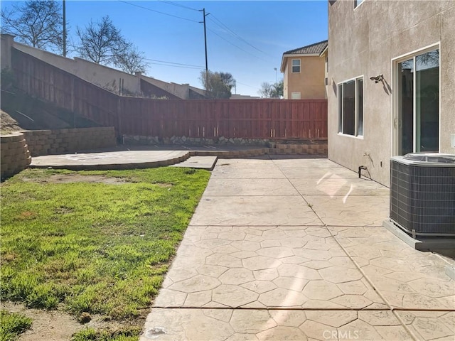 view of yard featuring a patio, central AC, and fence