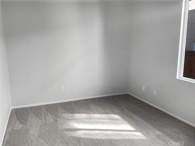 carpeted empty room with baseboards