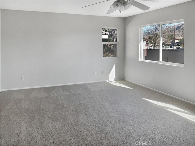 unfurnished room with carpet floors, baseboards, and a ceiling fan