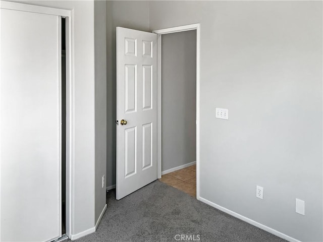 unfurnished bedroom featuring carpet floors and baseboards