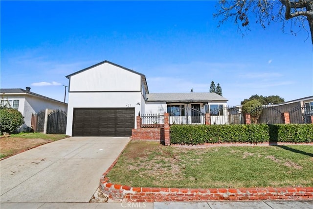 view of front of house with a fenced front yard, a front yard, driveway, and a garage