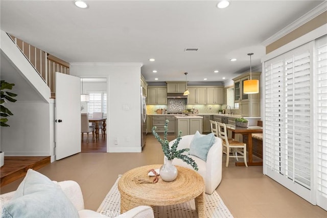 living room with baseboards, ornamental molding, visible vents, and recessed lighting