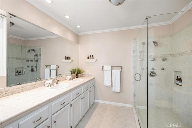 bathroom featuring a sink, baseboards, ornamental molding, double vanity, and a stall shower