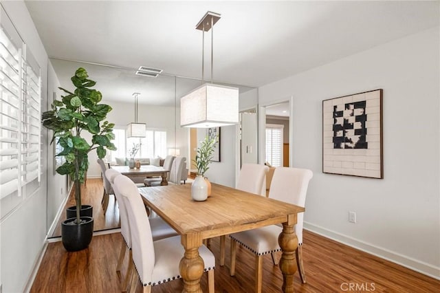 dining room with visible vents, baseboards, and wood finished floors