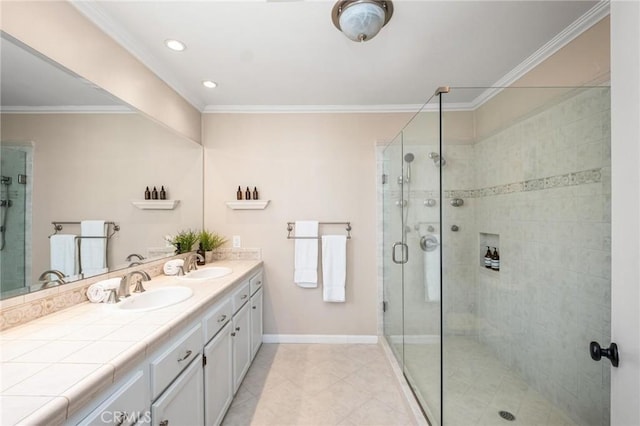 full bath with crown molding, double vanity, a sink, a shower stall, and baseboards