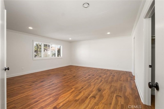 empty room featuring dark wood finished floors, crown molding, baseboards, and recessed lighting