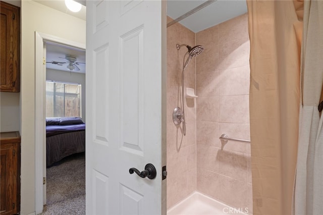 ensuite bathroom featuring a stall shower, ceiling fan, and ensuite bath