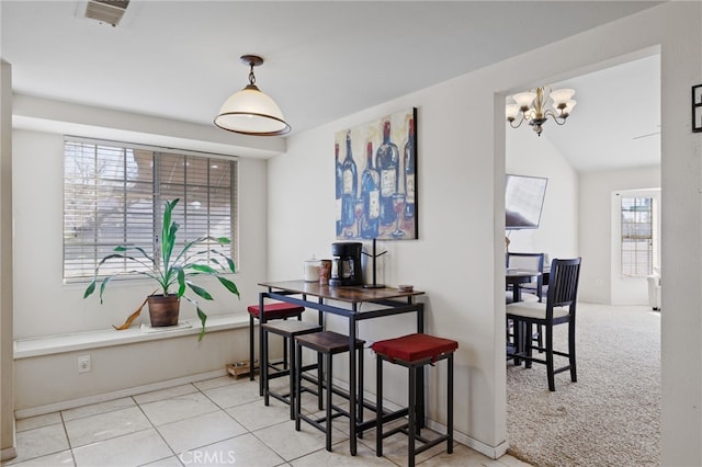 dining area featuring light carpet, light tile patterned floors, visible vents, lofted ceiling, and a chandelier