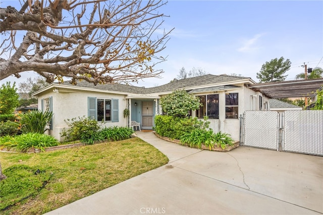 single story home with roof with shingles, stucco siding, a gate, an attached carport, and a front lawn