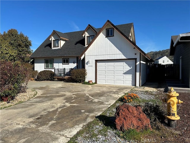 view of front of property with driveway, a shingled roof, and a garage