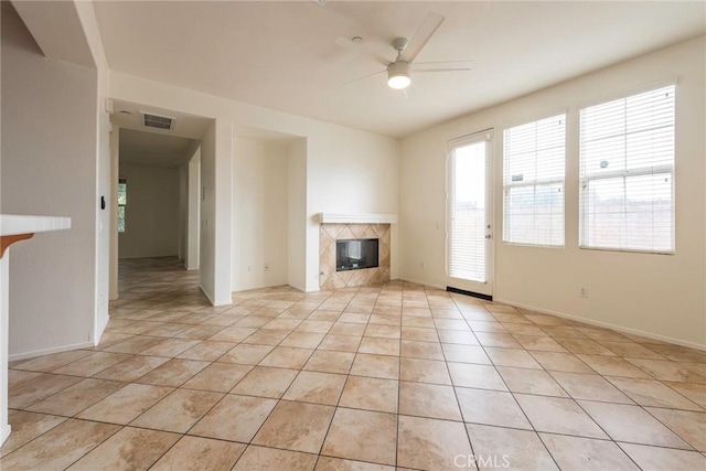 unfurnished living room featuring light tile patterned floors, visible vents, a ceiling fan, a high end fireplace, and baseboards