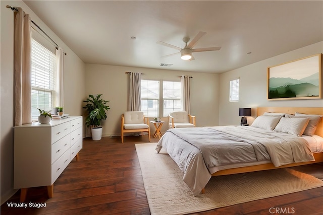 bedroom featuring ceiling fan, visible vents, dark wood finished floors, and multiple windows