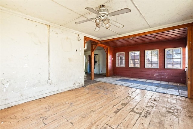 empty room with hardwood / wood-style flooring, ceiling fan, and crown molding