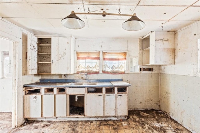 kitchen featuring open shelves, a sink, and white cabinetry