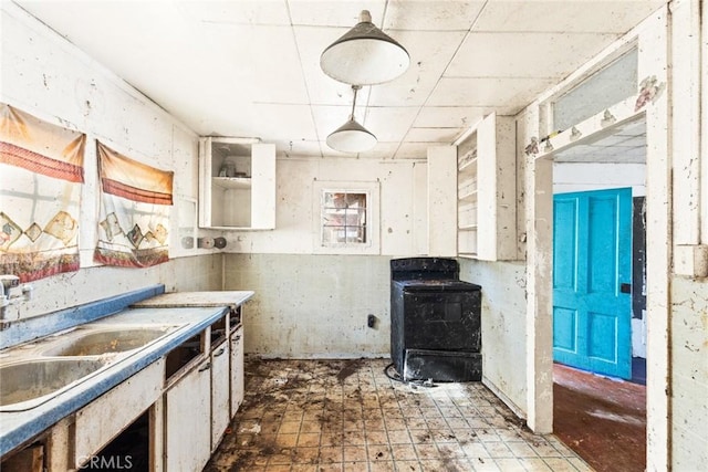 kitchen with light countertops, a sink, range, and white cabinets