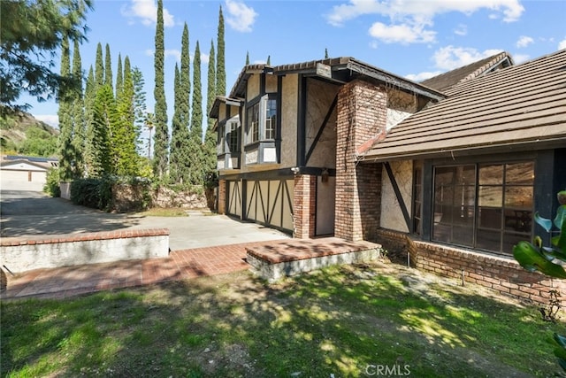 exterior space featuring an attached garage, a yard, and stucco siding