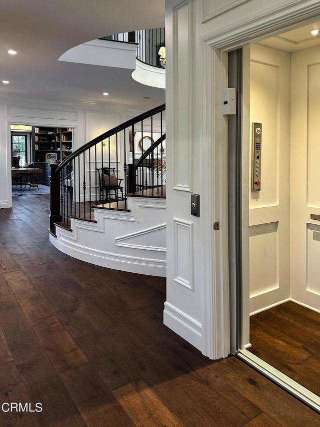 stairs with recessed lighting, hardwood / wood-style flooring, and elevator