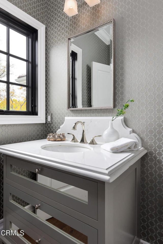 bathroom with vanity and wallpapered walls