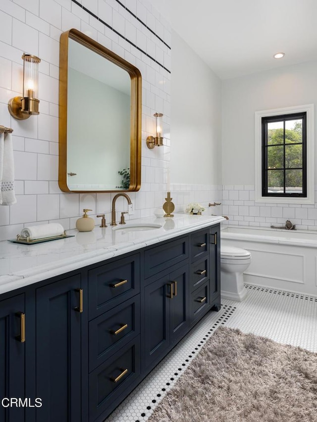 full bath with a washtub, tile walls, toilet, vanity, and tile patterned flooring