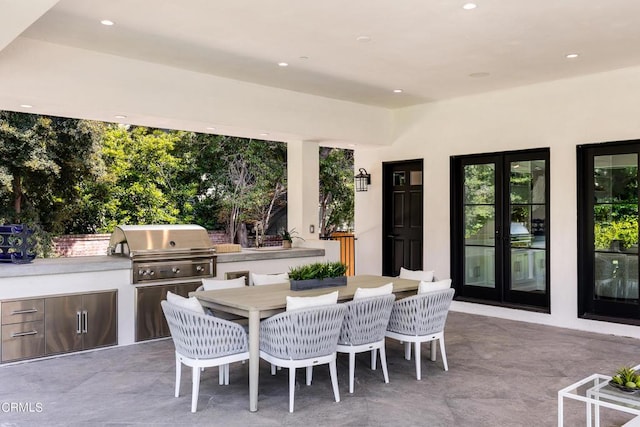 view of patio / terrace featuring outdoor dining area, a grill, and an outdoor kitchen