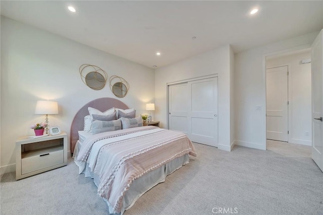 bedroom featuring recessed lighting, a closet, light colored carpet, and baseboards