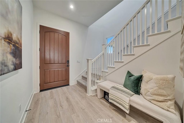 entrance foyer with light wood finished floors, stairs, baseboards, and recessed lighting