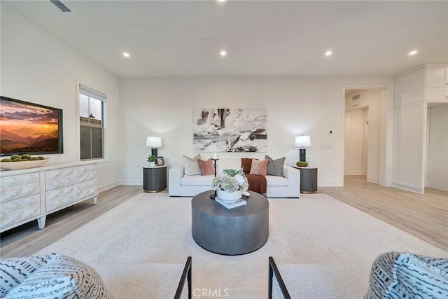 living area featuring recessed lighting, visible vents, and light wood finished floors