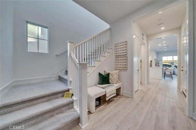 stairs with recessed lighting, baseboards, and wood finished floors