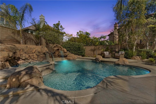 pool at dusk featuring fence and a fenced in pool