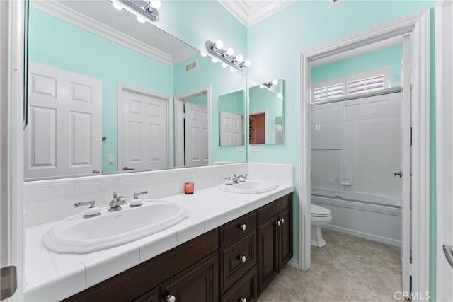 bathroom with crown molding, a sink, toilet, and double vanity