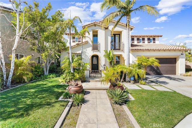 mediterranean / spanish house with concrete driveway, a balcony, an attached garage, a front yard, and stucco siding