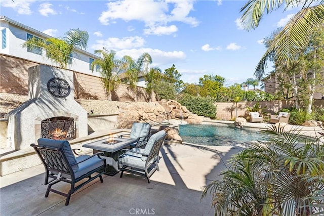 view of swimming pool featuring an outdoor fire pit, a fenced backyard, an outdoor stone fireplace, a fenced in pool, and a patio area