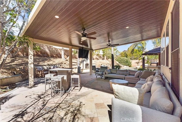 view of patio / terrace with fence, an outdoor living space, a ceiling fan, and outdoor dining space