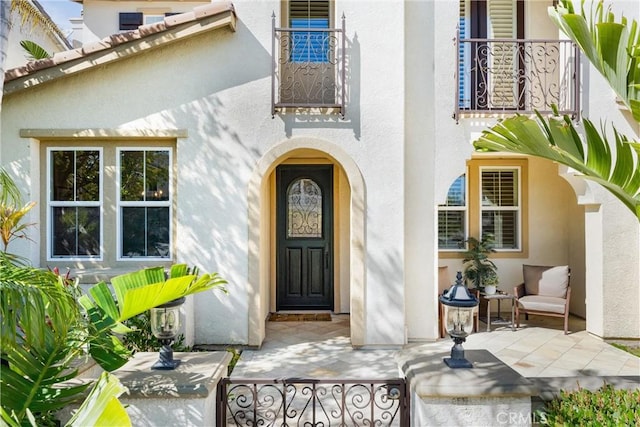 doorway to property featuring stucco siding