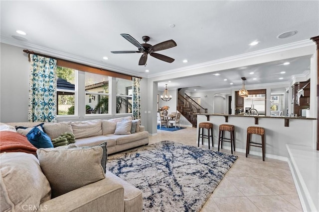 living area featuring ornamental molding, light tile patterned flooring, baseboards, and stairs