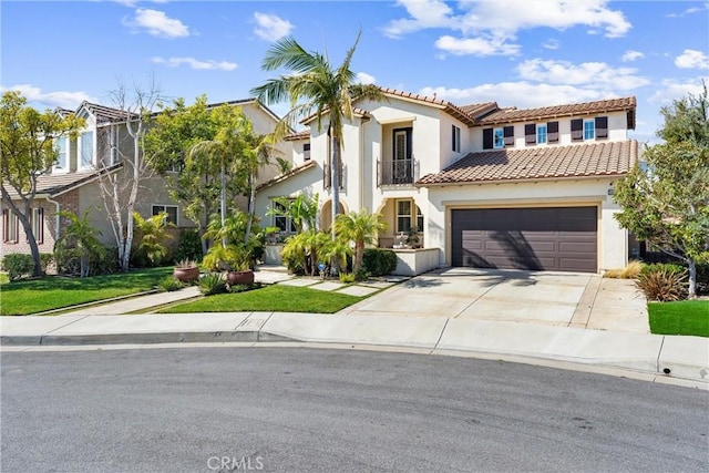 mediterranean / spanish-style house featuring stucco siding, concrete driveway, an attached garage, a balcony, and a tiled roof