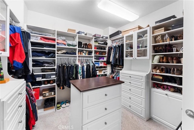 walk in closet featuring light colored carpet