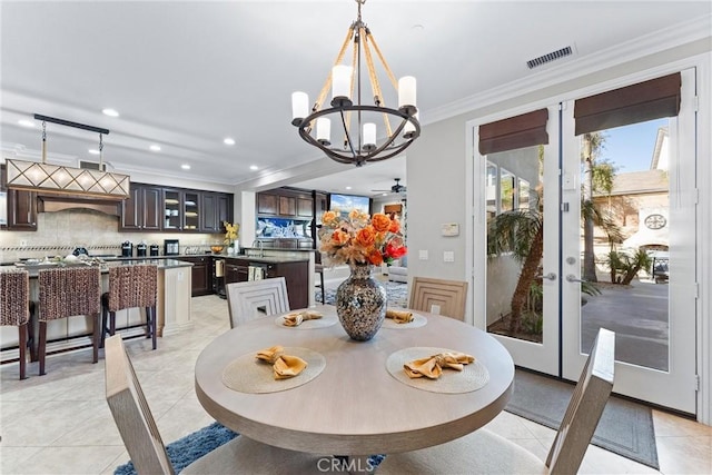 dining room with light tile patterned floors, french doors, ornamental molding, and visible vents