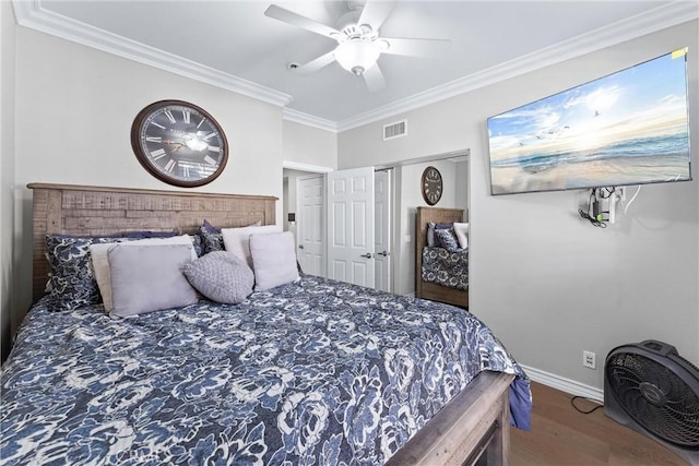 bedroom featuring crown molding, visible vents, a ceiling fan, wood finished floors, and baseboards