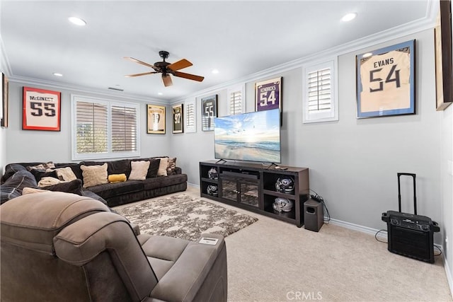 carpeted living area with ceiling fan, ornamental molding, a wealth of natural light, and baseboards