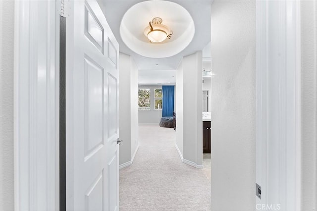 corridor with light colored carpet and baseboards