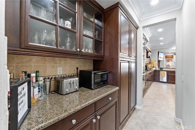 kitchen with dark brown cabinetry, a toaster, tasteful backsplash, ornamental molding, and light tile patterned flooring