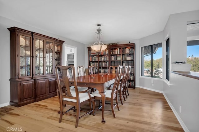 dining room featuring light wood-style flooring and baseboards